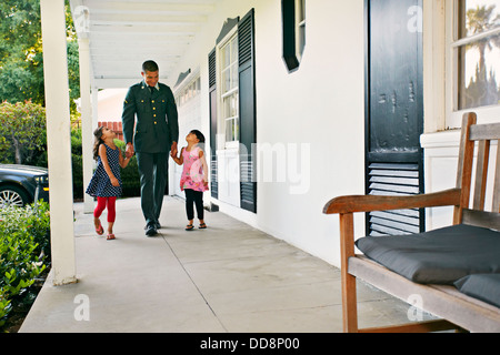 Soldato padre con le figlie sul patio Foto Stock