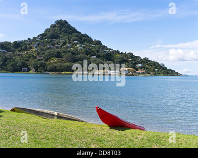 Dh Tairua Penisola di Coromandel NUOVA ZELANDA Lungomare canoa spiaggiata vista Paku in kayak di mare Foto Stock