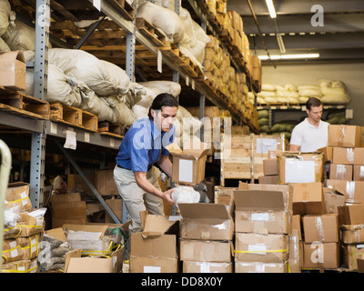 Lavoratori scatole di impilamento in fabbrica tessile Foto Stock