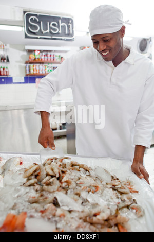 Razza mista drogheria preparazione del pesce nel mercato Foto Stock