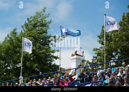 LTA e Aegon flutter bandiera nel vento al di sopra di spettatori in una ventilata giornata d'estate al Aegon torneo internazionale di tennis Foto Stock