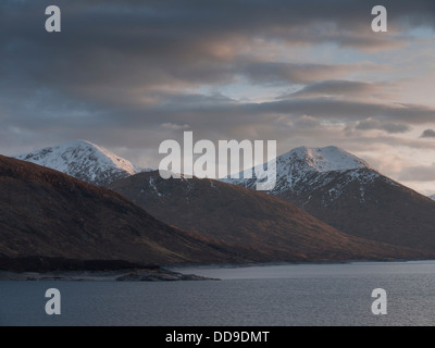 La vista sul Loch Quoich verso le montagne Sgurr Mor e Sgurr na Fhuarain al tramonto, a nord-ovest di Highlands, Scotland, Regno Unito Foto Stock