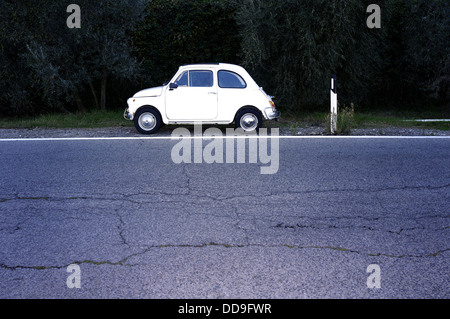 Vecchia auto italiane FIAT 500 su una strada nel deserto Foto Stock