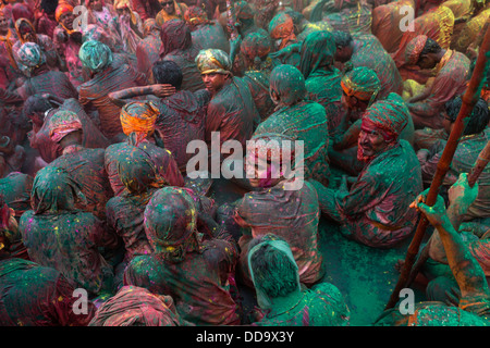 Durante Holi festival, emissari gruppo canta nel centro del tempio mentre altri potrebbe gettare polvere colorata e acqua Foto Stock