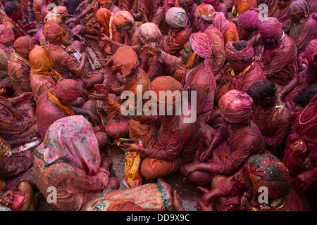 Durante Holi festival, emissari gruppo canta nel centro del tempio mentre altri potrebbe gettare polvere colorata e acqua Foto Stock