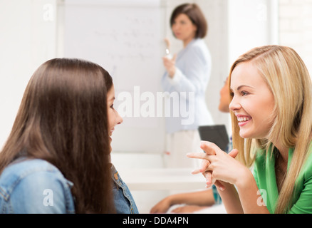 Studente ragazze spettegolare a scuola Foto Stock