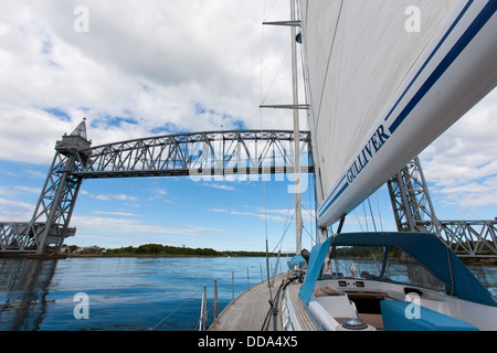 Uno yacht a vela con una bandiera britannica si avvicina al canale di Cape Cod ponte ferroviario nel canale di Cape Cod in Massachusetts, STATI UNITI D'AMERICA Foto Stock