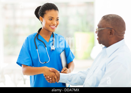 Friendly African American Medical handshaking infermiere con paziente senior Foto Stock