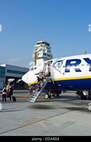 I passeggeri di sbarco da un ryanair airbus 320 all'aeroporto di Tenerife Sud, torre di controllo dietro, Isole canarie, Spagna Foto Stock