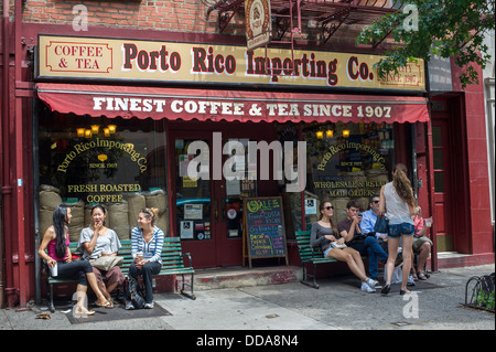 La gente si vede seduto al di fuori del Porto Rico società importatrice, un negozio che vende accessori per caffè e tè, nel Greenwich Village di New York Foto Stock