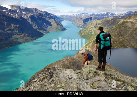 Due escursionisti in procinto di scendere lungo la ripida cresta Besseggen nel Parco nazionale di Jotunheimen Norvegia tra il Lago Gjende e Bessvatnet Foto Stock