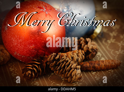 Merry Christmas card con ornamenti e pigne, grungy Foto Stock