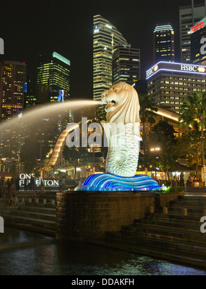 Dh Merlion Park MARINA BAY SINGAPORE statua Merlion notte tempo città delle luci skyscappers fontana Foto Stock