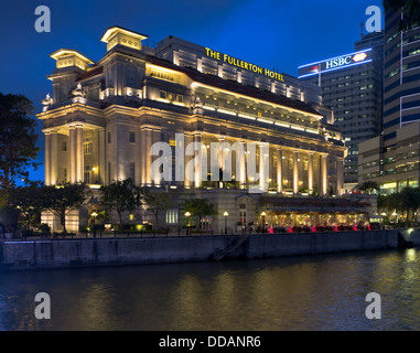 Dh Fiume Singapore DOWNTOWN CORE SINGAPORE Il Fullerton Hotel occupa un edificio di sera illuminate di luce alberghi Foto Stock