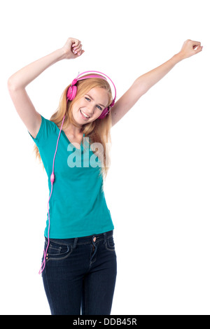 Donna godendo della sua musica agitando le braccia in aria e ridere come ascolta la musica sul suo cuffie Foto Stock