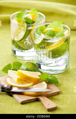 Il freddo limonata fresca con limone e calce su sfondo verde Foto Stock