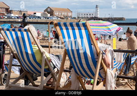 Primo piano di persone che visitano anziani donne anziane sedute su sdraio in estate Scarborough North Yorkshire Inghilterra Regno Unito Gran Bretagna Foto Stock