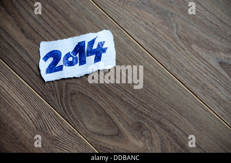 Anno nuovo scritto sul pezzo di carta su un sfondo di legno. Spazio per il testo. Foto Stock