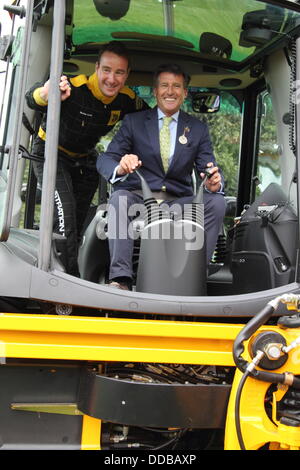 Derbyshire, Regno Unito. Il 30 agosto, 2013. Matt 'Il Dig' Lucas da JCB Team di dimostrazione con Lord Sebastian Coe ai comandi di un escavatore JCB sul giorno del lancio di Chatsworth Country Fair, Peak District, Derbyshire, Regno Unito. Credito: Deborah Vernon/Alamy Live News Foto Stock