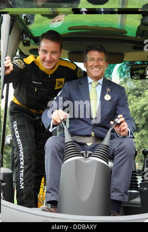 Derbyshire, Regno Unito. Il 30 agosto, 2013. Matt 'Il Dig' Lucas da JCB Team di dimostrazione con Lord Sebastian Coe ai comandi di un escavatore JCB sul giorno del lancio di Chatsworth Country Fair, Peak District, Derbyshire, Regno Unito. Credito: Deborah Vernon/Alamy Live News Foto Stock