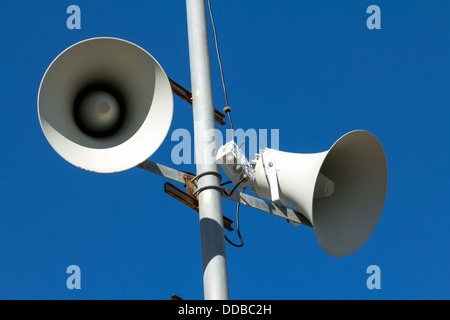 Una torre di indirizzo pubblico set di altoparlanti contro un cielo blu. Foto Stock