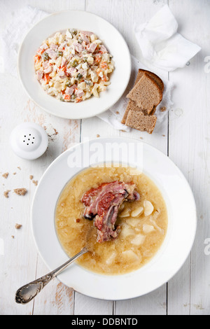 Tradizionale russa insalata russa e la zuppa di piselli con pane e nervature affumicato Foto Stock