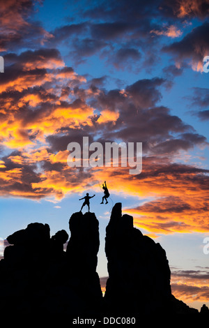 Team di alpinisti conquistare la vetta di un impegnativo guglia di roccia. Foto Stock