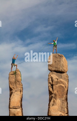 Team di arrampicatori maschio conquistare la vetta di un impegnativo guglia di roccia. Foto Stock