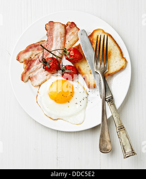 La prima colazione con uova fritte e pancetta sulla piastra Foto Stock