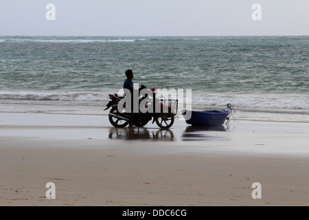 Un pescatore sul suo modo alla sua barca Foto Stock