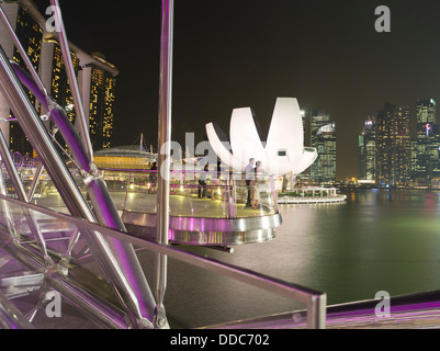 Dh l arte del Museo della SCIENZA MARINA BAY SINGAPORE giovane viewpoint serata luci notturne di Helix bridge turisti cityscape turismo Foto Stock