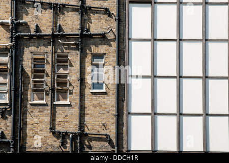 Muro Esterno vecchio edificio nella zona est di Londra, tubi formano una configurazione astratta. Foto Stock