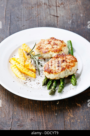 Fishcakes con patatine fritte e gli asparagi Foto Stock