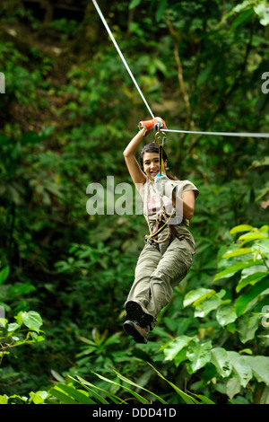 Una donna piomba giù un zip line. Foto Stock