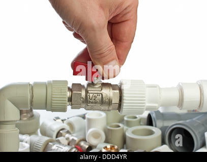 Set di raccordi idraulici in sua mano isolati su sfondo bianco Foto Stock