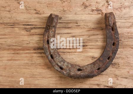 Vecchio arrugginito a ferro di cavallo su un sfondo di legno Foto Stock