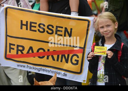 Kassel, Germania. 31 Agosto, 2013. Persone di manifestare contro fracking con poster e carte rosse di fronte alla sede della più grande della Germania petrolio greggio e gas naturale produttore Wintershall a Kassel in Germania, 31 agosto 2013. Iniziatore della dimostrazione con il motto "Cartellino rosso per Wintershall' è BUND Hessen. Foto: UWE ZUCCHI/dpa/Alamy Live News Foto Stock