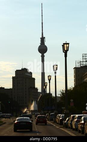 Auto Drive su Karl-Marx-Allee street verso Strausberger Platz con ols lampade stradali e la torre della TV in background e in serata a Berlino (Germania), 28 agosto 2013. Foto: Jens KALAENE Foto Stock