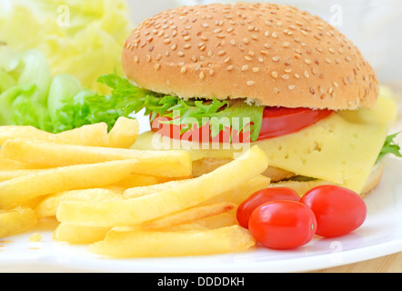 Patatine fritte e cheeseburger sulla piastra bianca Foto Stock