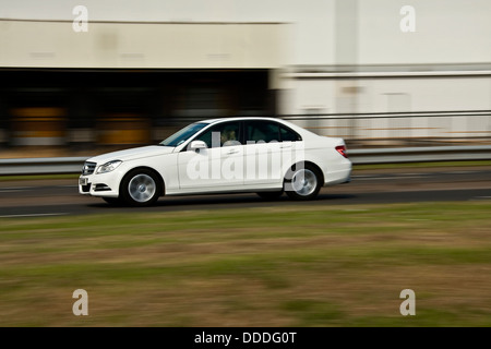 Un bianco di classe Mercedes Benz automobile che viaggia lungo il Kingsway West a doppia carreggiata a Dundee, Regno Unito Foto Stock