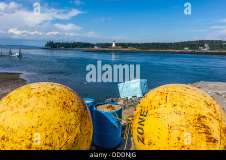 Una vista di Lubec, Maine seashore con un grande metallo giallo galleggianti in primo piano Mulholland Point lighthouse in background. Foto Stock