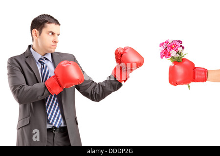 L'uomo arrabbiato con i guantoni di colpire una mano con il guanto di inscatolamento e mazzo di fiori Foto Stock