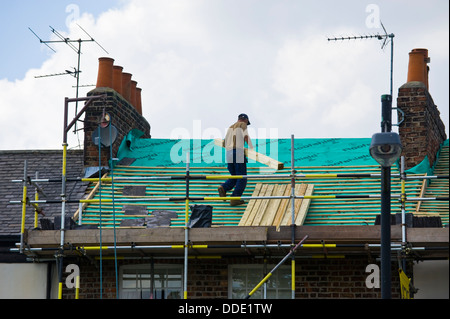Builder a lavorare sul tetto della casa d'epoca nella città di York North Yorkshire England Regno Unito Foto Stock