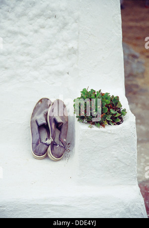 Vecchie scarpe di tela sulla parete dipinta di bianco. Isola di Minorca. Isole Baleari. Spagna. Foto Stock