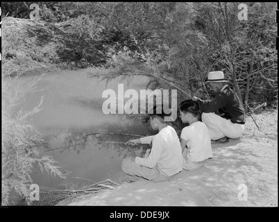 Gli sfollati di origine giapponese al campo di internamento di Poston in Arizona pescano le carpe in un canale sul lato nord-ovest del campo, riflettendo la vita quotidiana durante l'internamento in tempo di guerra. Foto Stock