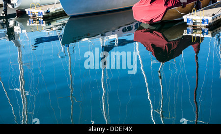 Barche a vela ormeggiata blend con belle immagini acquosa di scafi in barca & esitazioni a montanti contro il cielo blu Edmonds yacht harbour marina Foto Stock