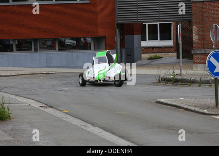 Il bianco e il verde racing buggy prendendo una curva su 3 ruote su asfalto. Incentrato sulla vettura. Foto Stock