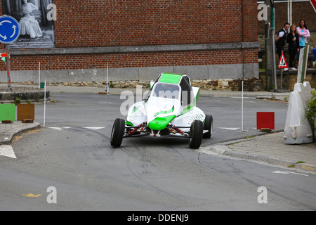 Il bianco e il verde racing buggy prendendo una curva su asfalto. Incentrato sulla vettura. Foto Stock
