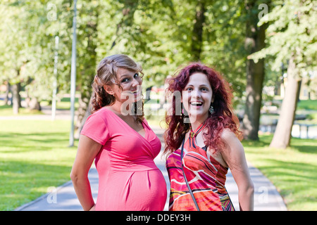 La donna incinta parla con la fidanzata in posizione di parcheggio Foto Stock