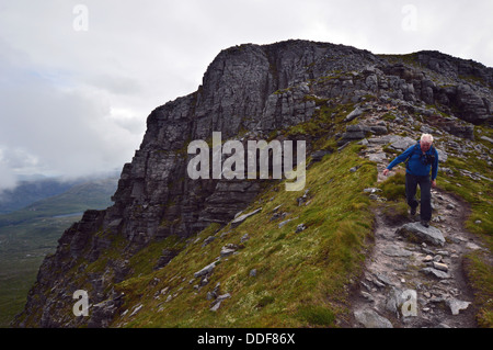 Il camminatore maschio lasciando il vertice di Spidean Coinich (a) Corbett sulla montagna scozzese Quinag nelle Highlands Scoland. Foto Stock